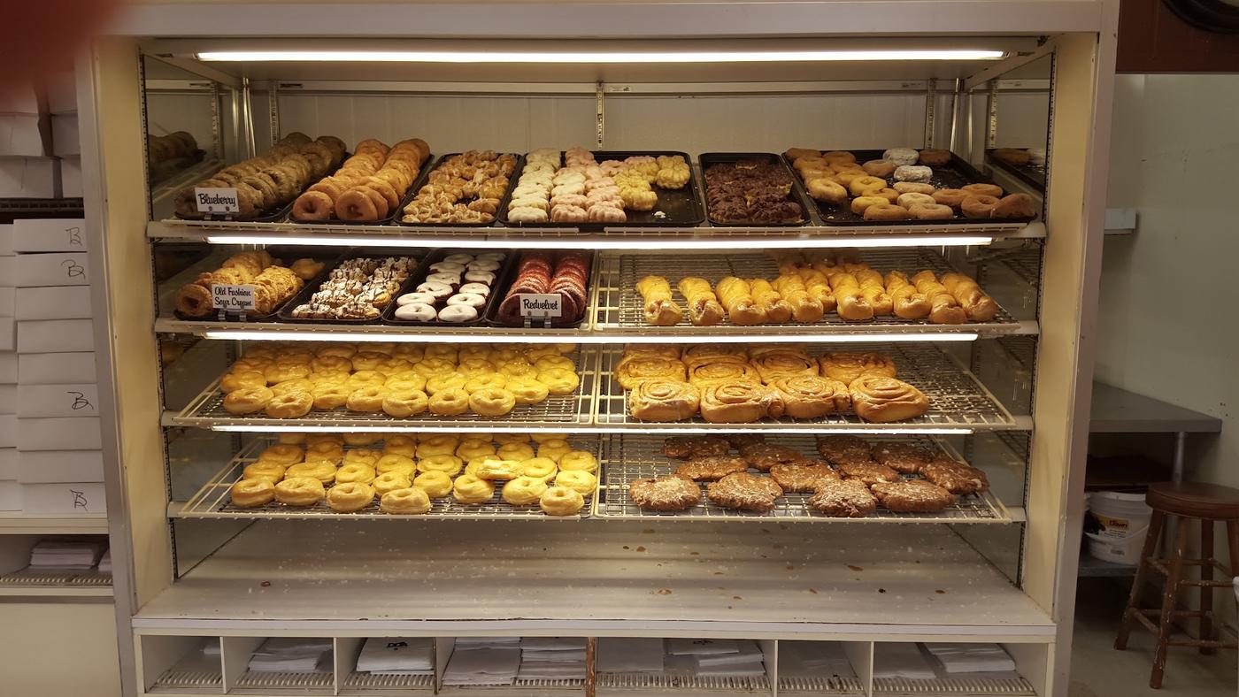 The tall rack case at Ray's, filled with blueberry and old fashion sour cream donuts, cinnamon rolls, fritters and bear claws.